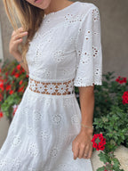 robe bohème dos nu en dentelle blanche courte avec manches évasées et chapeau de paille, modèle en plein air