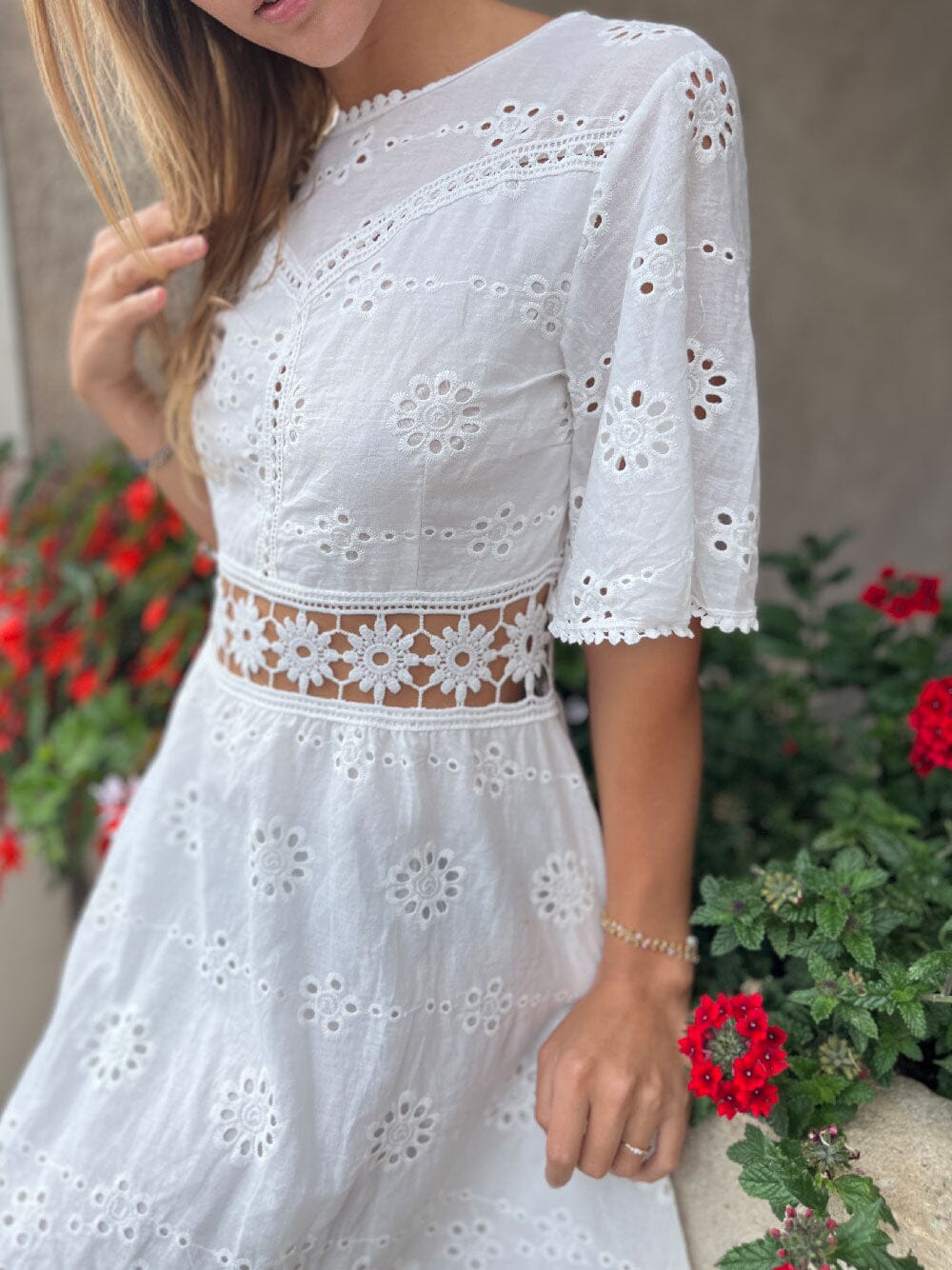 robe bohème dos nu en dentelle blanche courte avec manches évasées et chapeau de paille, modèle en plein air