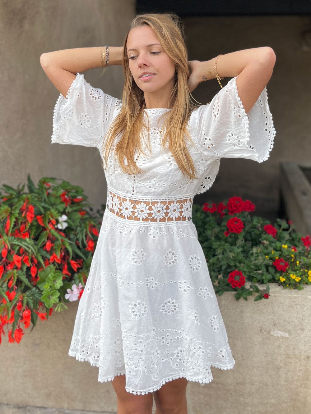 robe bohème dos nu en dentelle blanche courte avec manches évasées et chapeau de paille, modèle en plein air
