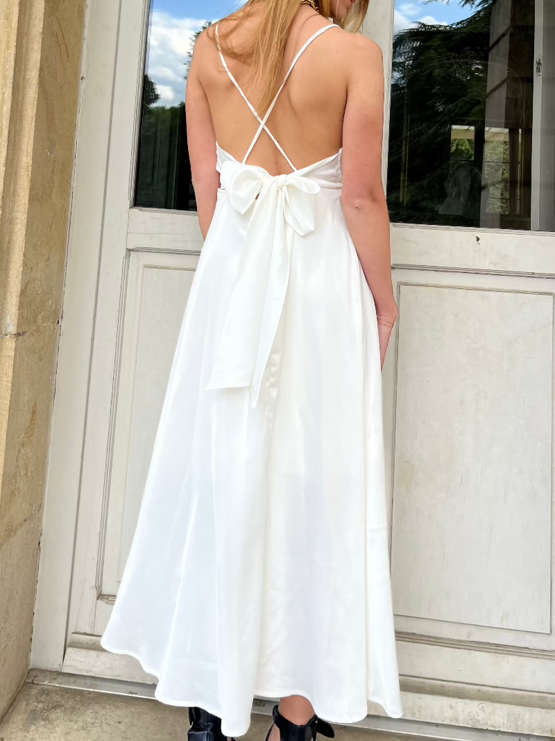 Robe satin dos nu tessa en soie blanche, coupe mi-longue élégante avec bretelles croisées, vue de dos romantique et chic.